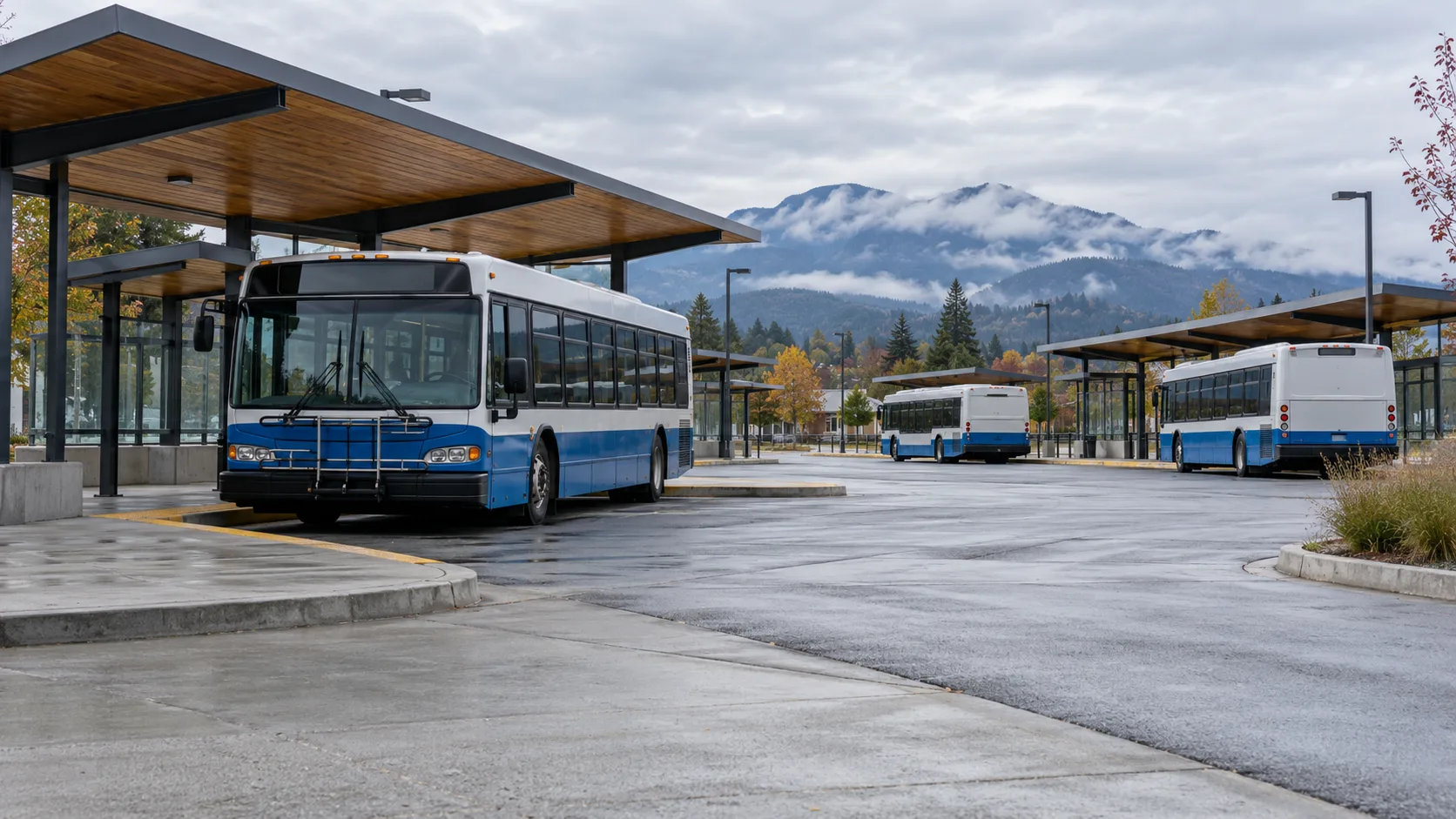 Buses at a suburban exchange with covered shelters and distant mountains