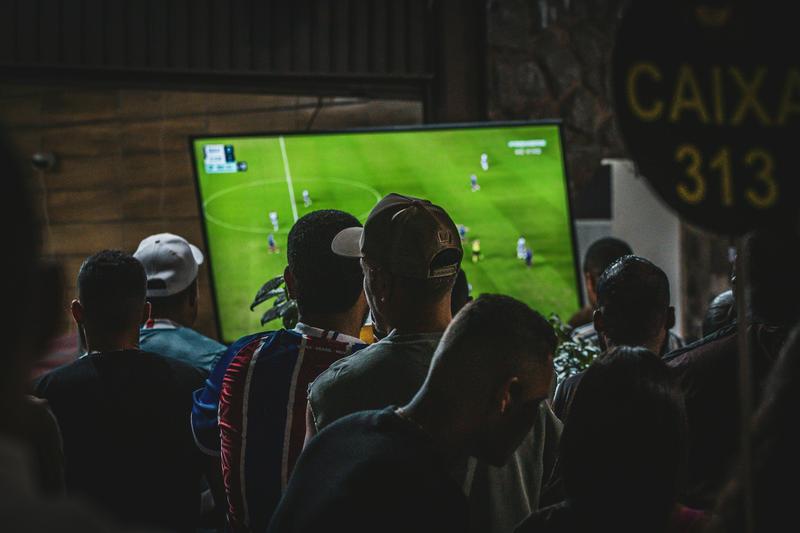 Fans watching a football match on a large screen