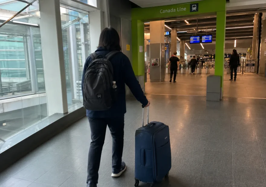 Traveler with luggage walking toward the Canada Line at YVR