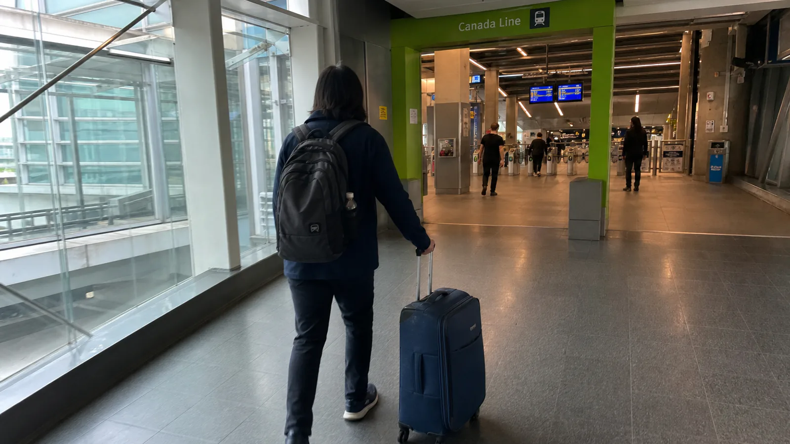 Traveler with luggage walking toward the Canada Line at YVR
