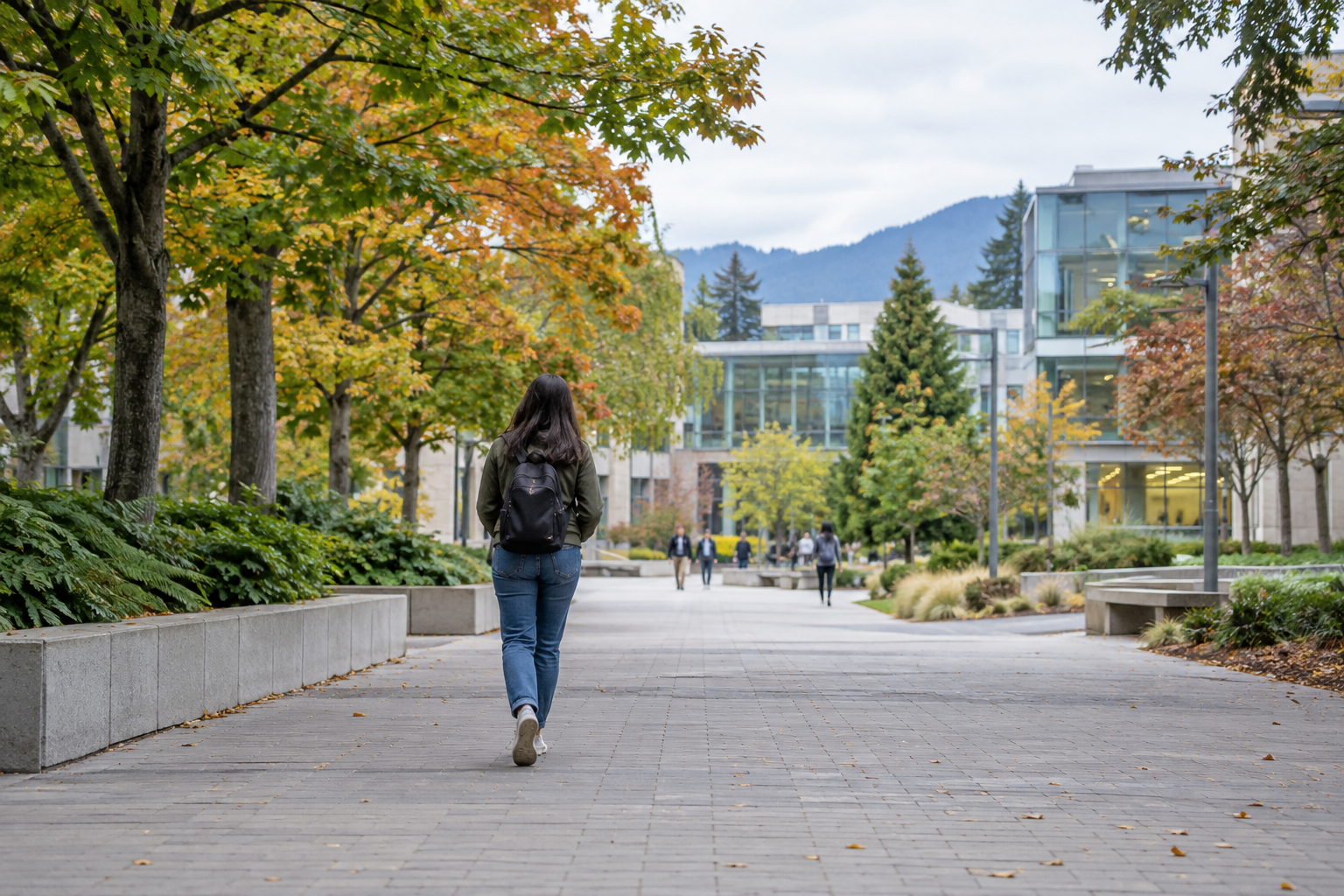 Visitor walking along a tree-lined UBC campus path