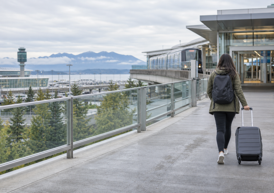 Traveller with a carry-on approaching a Vancouver airport rail station